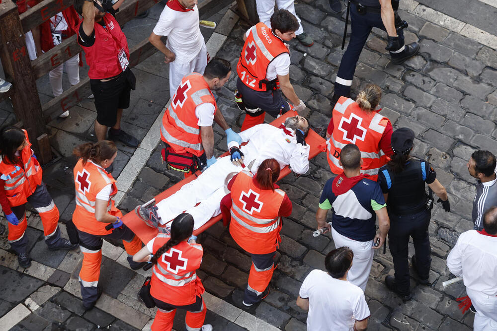  Los sanitarios trasladan a un herido durante, durante el octavo y último encierro de sanfermines este viernes en Pamplona con los legendarios toros de la ganadería de Miura.