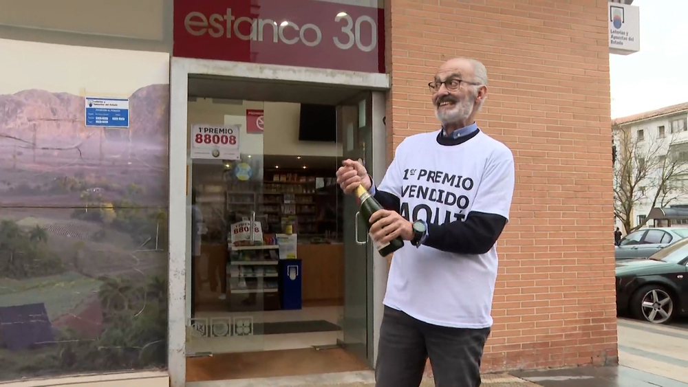 Santiago Gómez, lotero del estanco de la calle Magdalena nº3, descorcha champagne tras vender tres décimos de El Gordo  