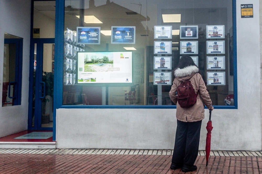 Una mujer observa las ofertas de una inmobiliaria