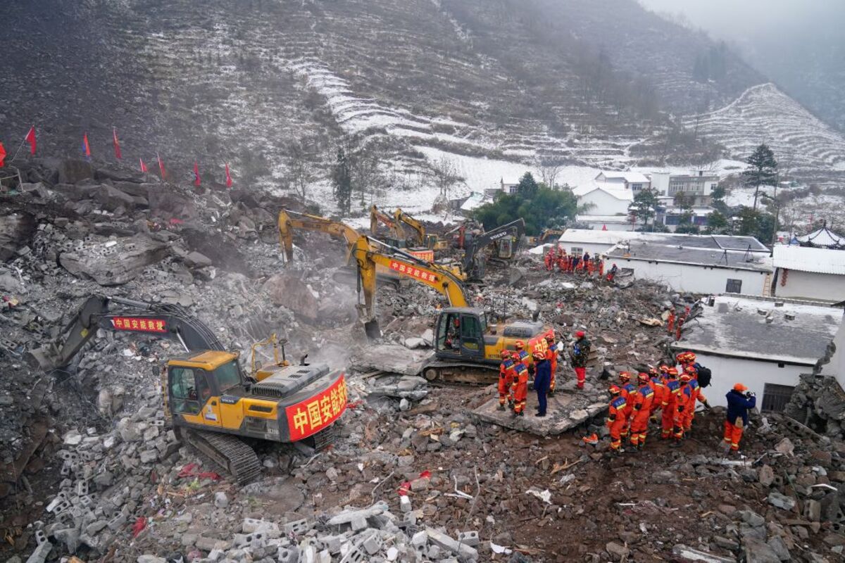 Rescue workers search for survivors in the debris after a landslide hit Zhenxiong county in Zhaotong  / STRINGER