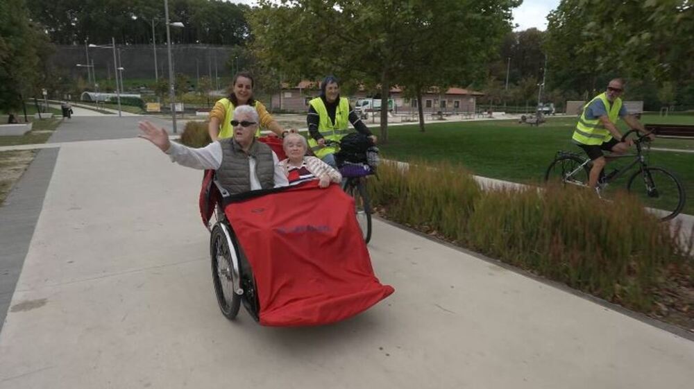 Residentes de centros de mayores disfrutando del paseo en triciclo